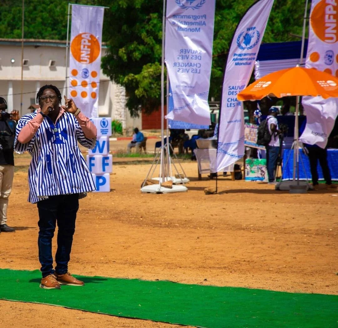 Sur scène devant les banderoles de l'UNFPA et du PAM